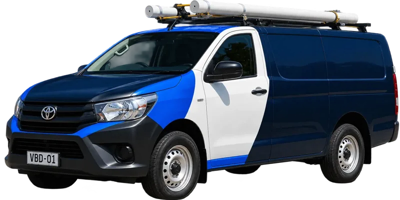 A licensed Carlingford plumbing van loaded with pipe on the roof rack